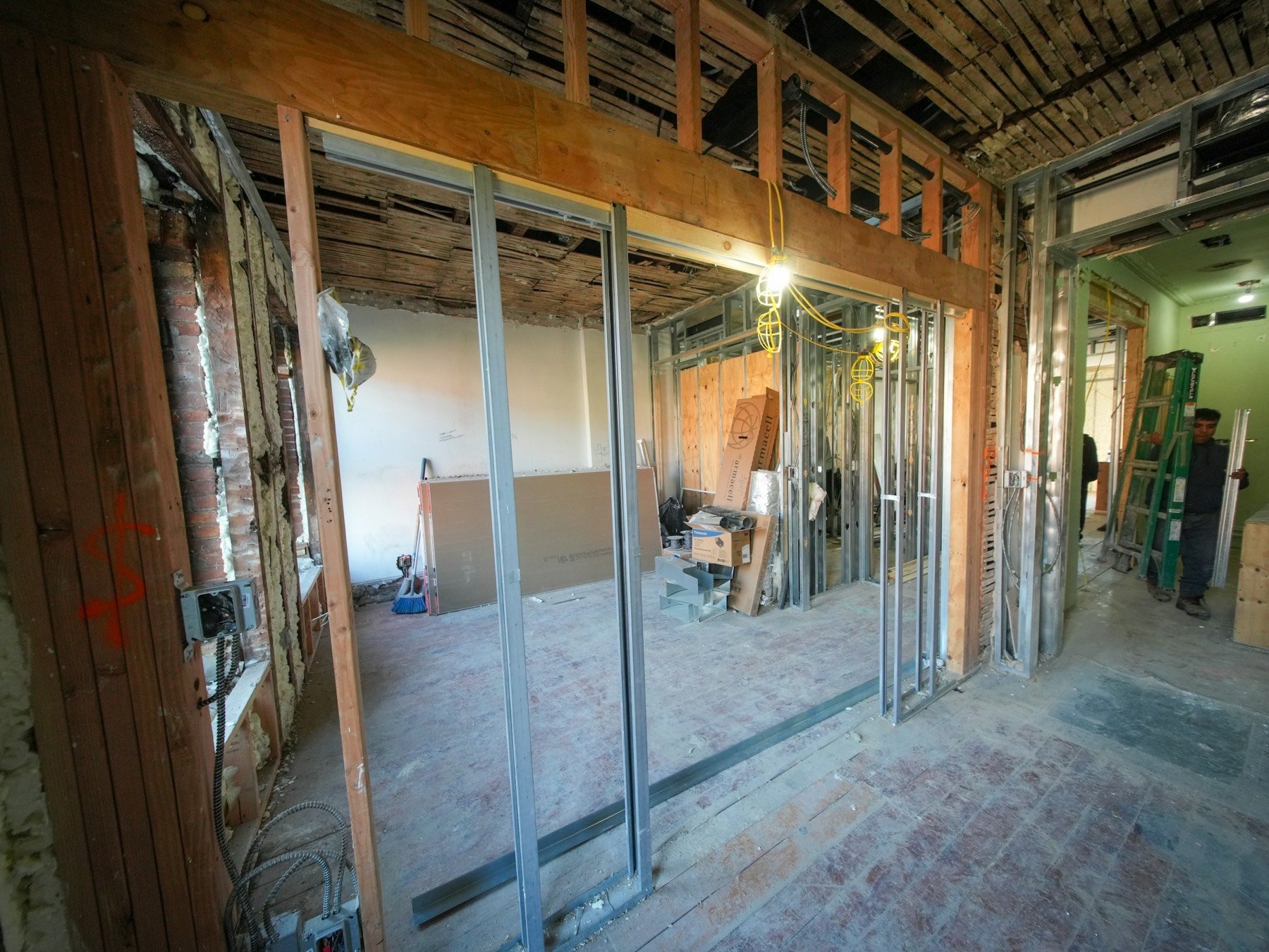 Commercial unit being fitted out, with steel stud framing and an open ceiling.
