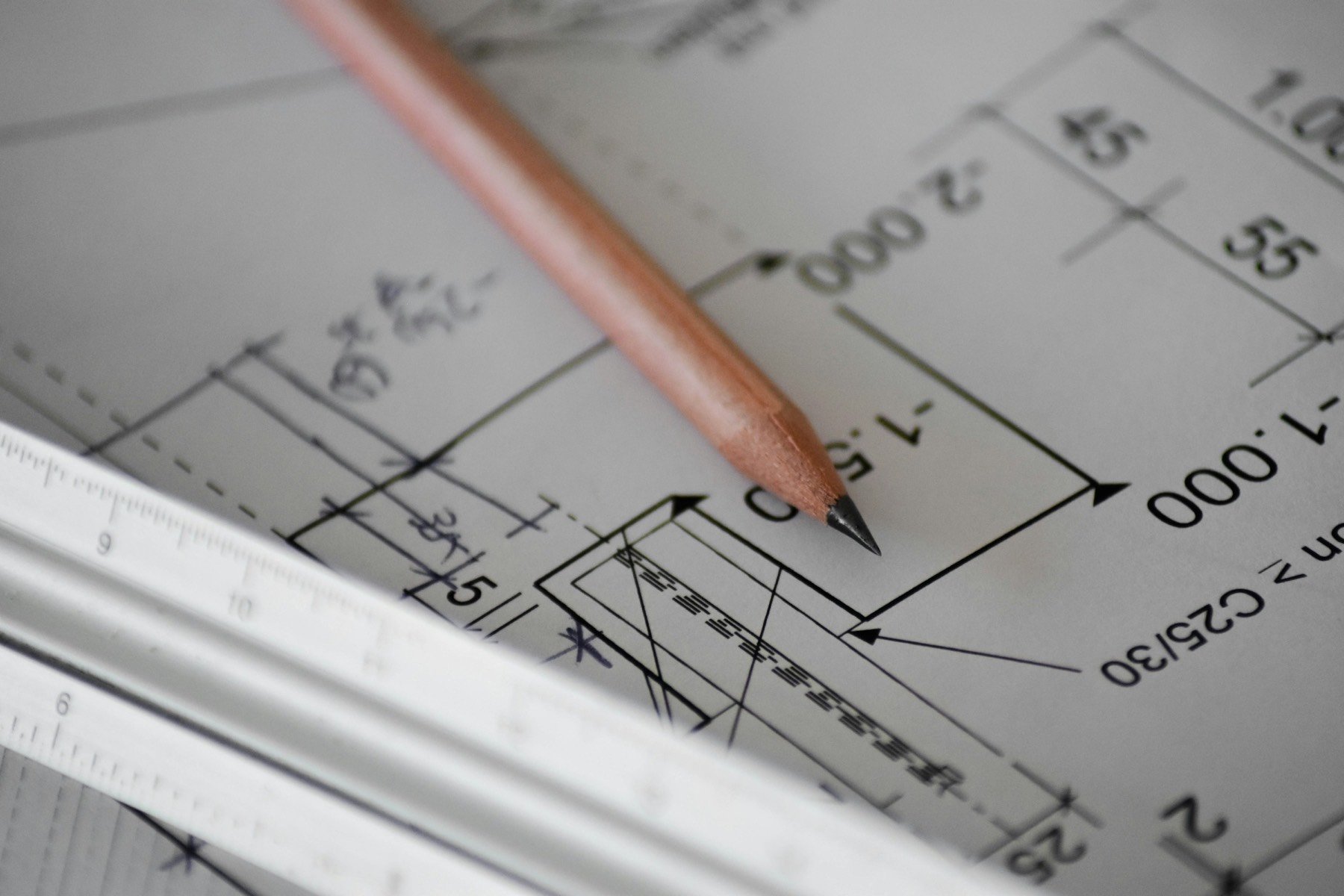 A pencil and a scale ruler on a set of building plans