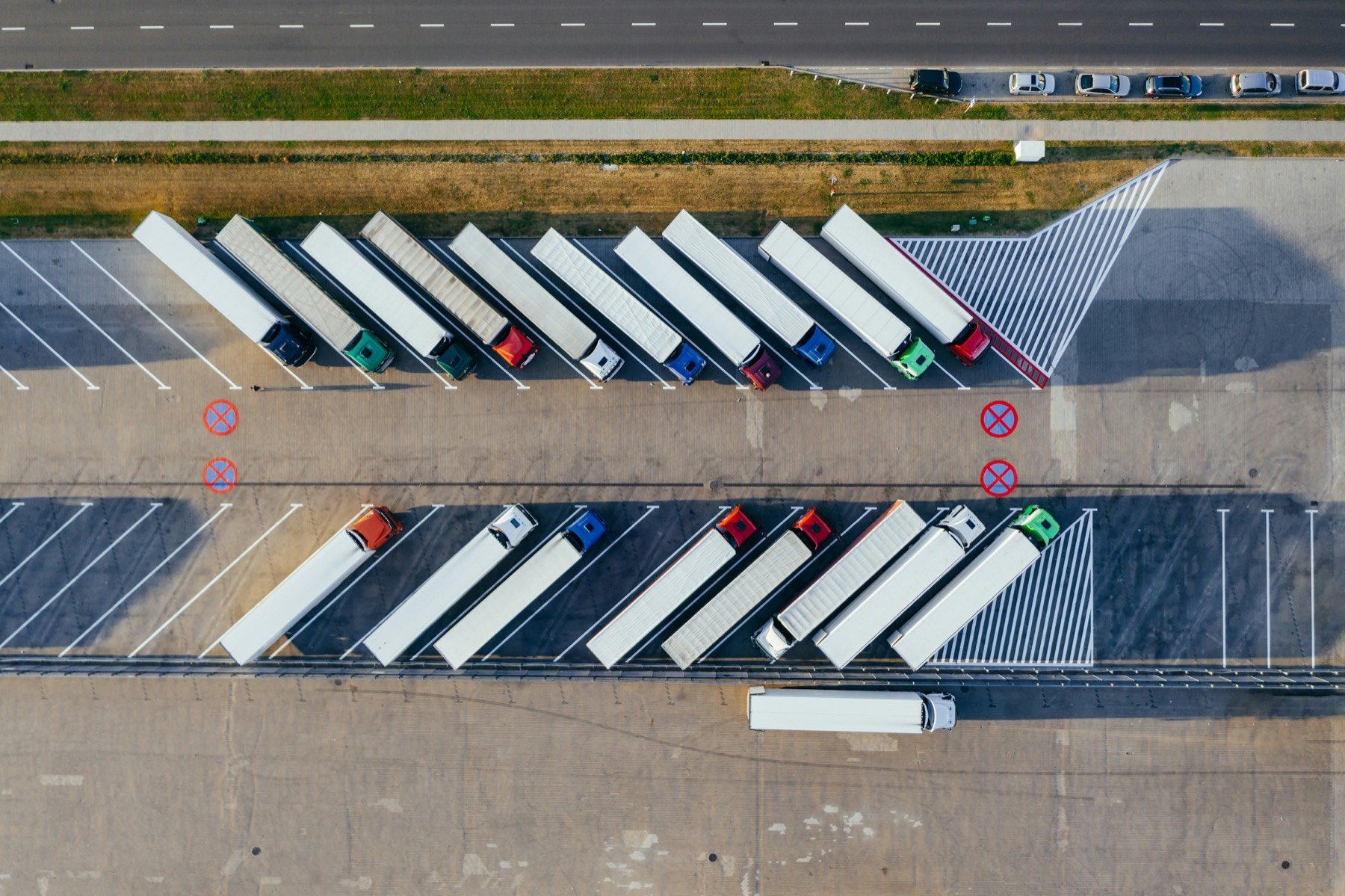 Aerial view of transport trucks and trailers parked in rows at a distribution lot