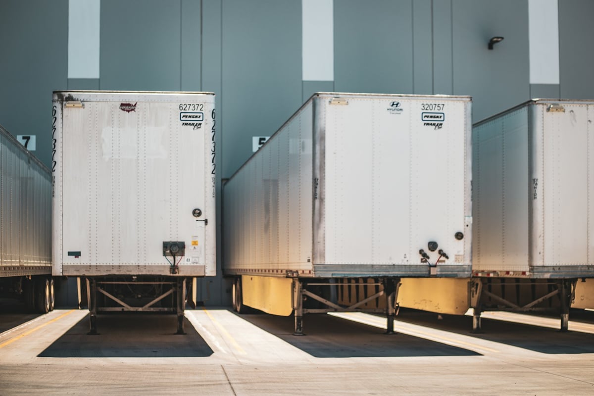 Semi-trailers backed into a row of loading docks at a distribution warehouse